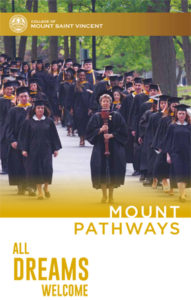 Mount students walk down the hill in their graduation gowns. 