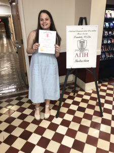 Christina Rasmussen '20 with a Lambda Pi Eta diploma.